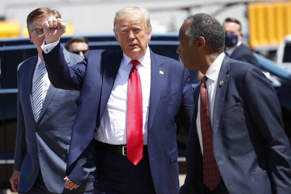 President Donald Trump walks with Texas Lt. Gov. Dan Patrick, left, and Housing and Urban Development Secretary Ben Carson as he arrives on Air Force One at Dallas Love Field, on June 11, 2020, in Dallas. (AP Photo/Alex Brandon)