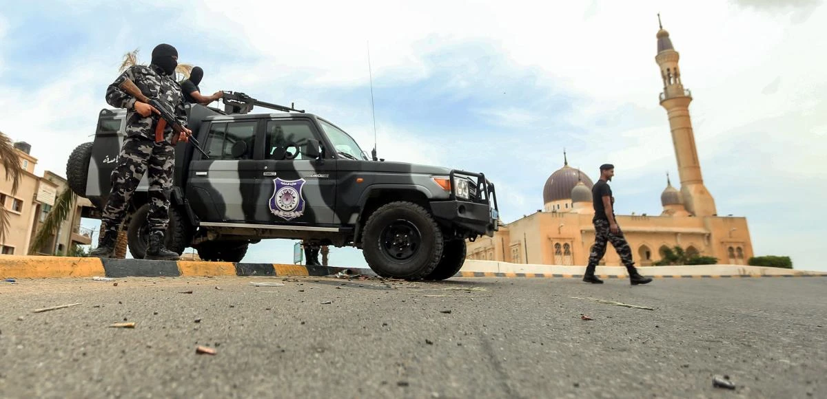 Members of security forces affiliated with the Libyan Government of National Accord (GNA)'s Interior Ministry stand at a make-shift checkpoint in the town of Tarhuna, about 65 kilometres southeast of the capital Tripoli on June 11, 2020. (AFP)