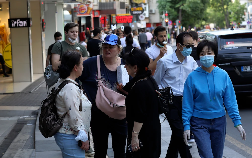 People, some wearing face masks to protect against the coronavirus, walk along a popular street, in Ankara, Turkey, Sunday, June 14, 2020. (AP)