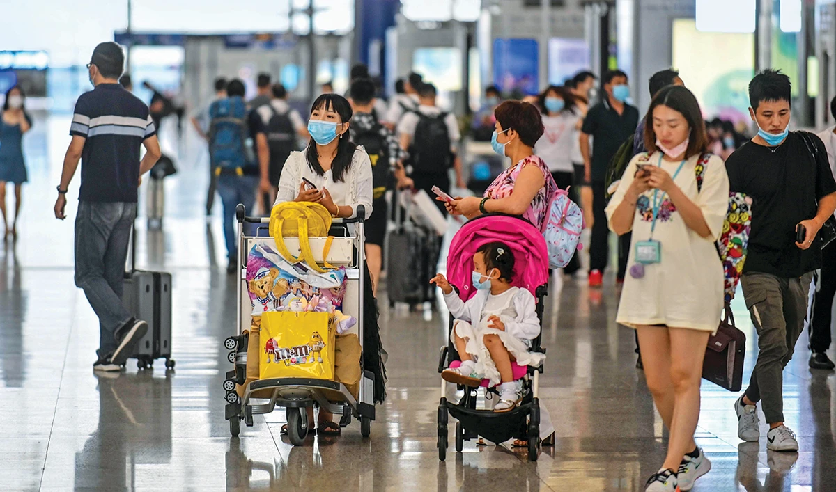 Passengers walk across a hall in Pudong International Airport in Shanghai following preventive procedures against the spread of the coronavirus. (AFP)