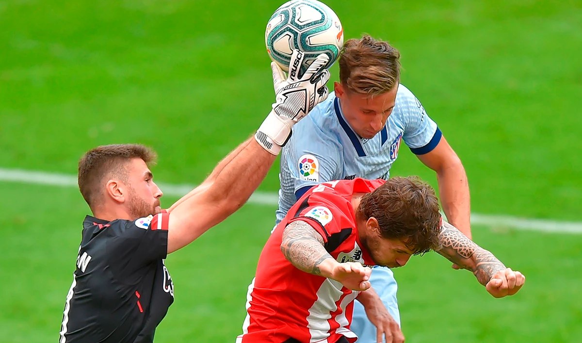 Atletico Madrid’s midfielder Marcos Llorente, right, up against Athletic Bilbao’s goalkeeper Unai Simon, left, and defender Inigo Martinez during the Spanish League football match. (AFP)