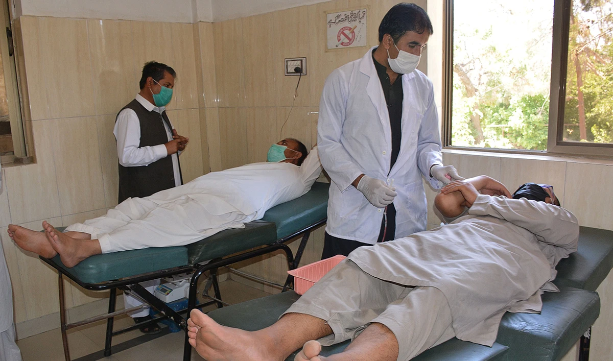 Health workers with the volunteers as they donate their blood during the World Blood Donor Day in Quetta on Sunday. (AFP)