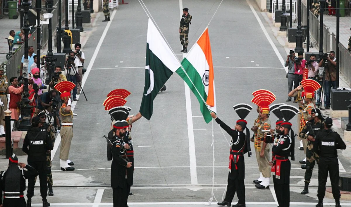 Pakistani Rangers (wearing black uniforms) and Indian Border Security Force (BSF) officers lower their national flags during a parade on Pakistan's 72nd Independence Day, at the Pakistan-India joint check-post at Wagah border, near Lahore, Pakistan on Aug. 14, 2018. (Reuters/File)