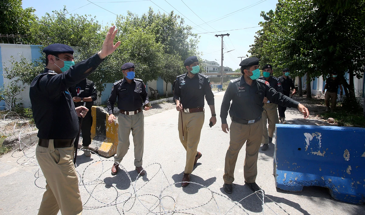 Pakistani police officers stand guard at a checkpoint of a restricted area to help contain the spread of new coronavirus, in Peshawar, Pakistan, Tuesday, June 16, 2020. (AP)