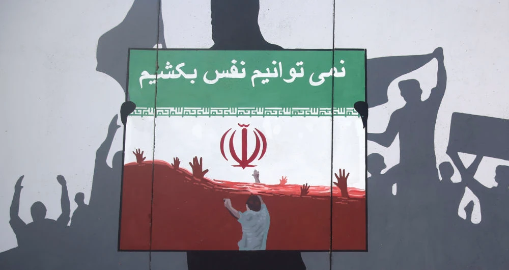 A view of a painting on a wall written in the Dari Language reading "We cannot breath" during a protest denouncing the killings of Afghan refugees in Iran in Kabul, Afghanistan, Monday, June 15, 2020. (AP)