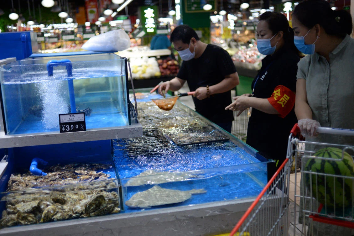 Customers wearing face masks shop live seafood at a Carrefour supermarket, following new cases of coronavirus disease (COVID-19) infections in Beijing, China June 17, 2020. (Reuters)