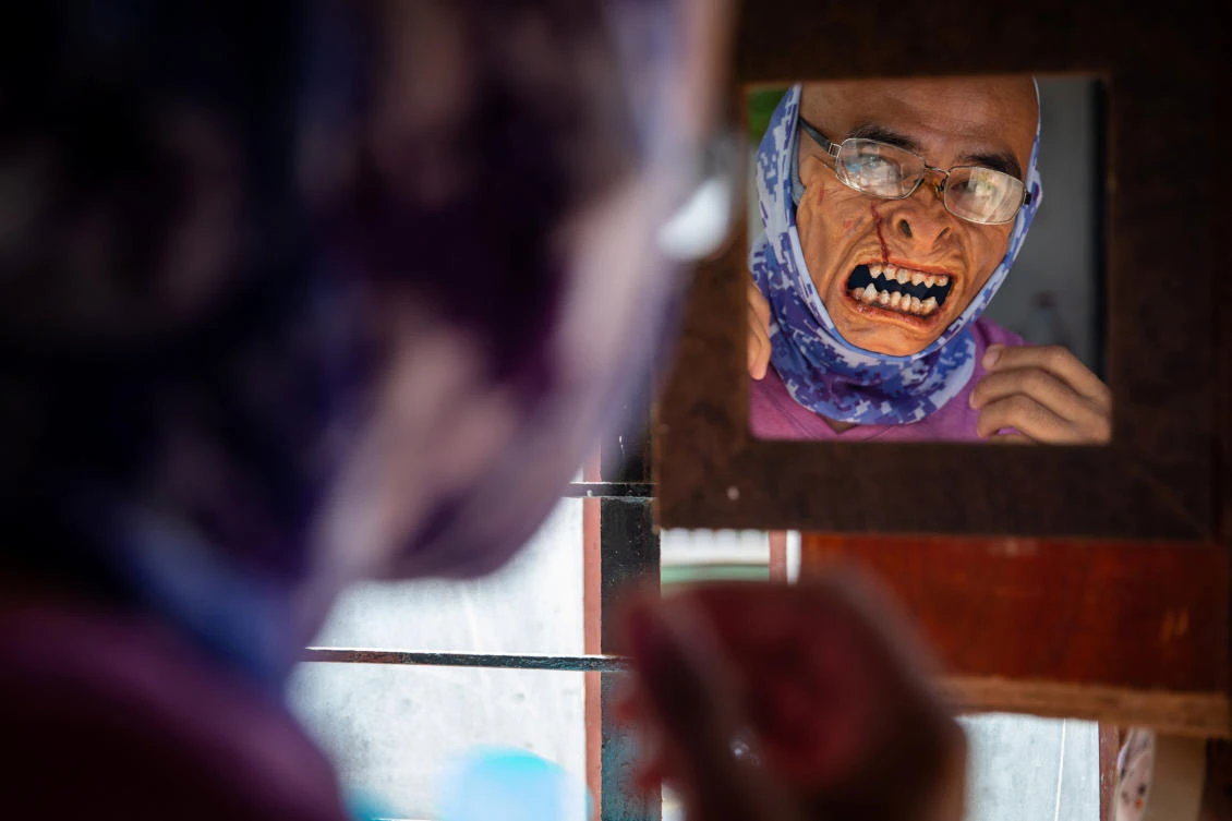 TV prosthetics artist Rene Abelardo tries on a sample of his prosthetic face masks. (Reuters)