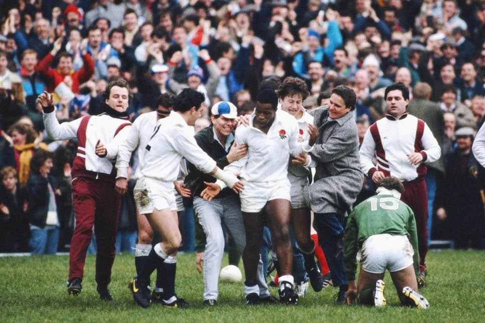 Will Carling congratulates Chris Oti as the wing becomes an England hat-trick hero and sparks the crowd into a rendition of Swing Low, Sweet Chariot in March 1988. (Getty Images)