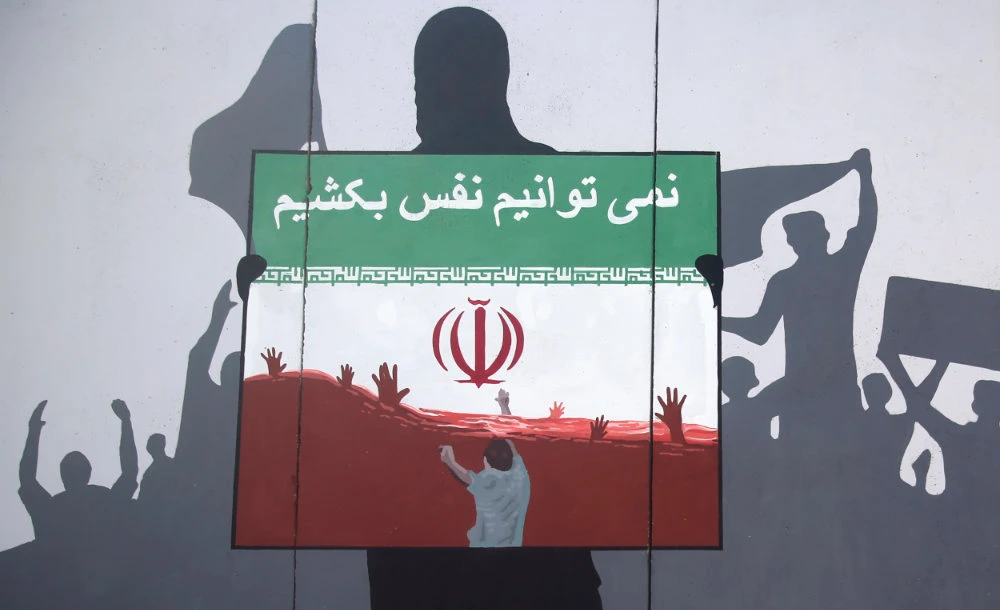 A view of a painting on a wall written in the Dari Language reading "We cannot breath" during a protest on June 15, 2020 in Kabul, Afghanistan, denouncing the killings of Afghan refugees in Iran. (AP Photo/ Rahmat Gul)