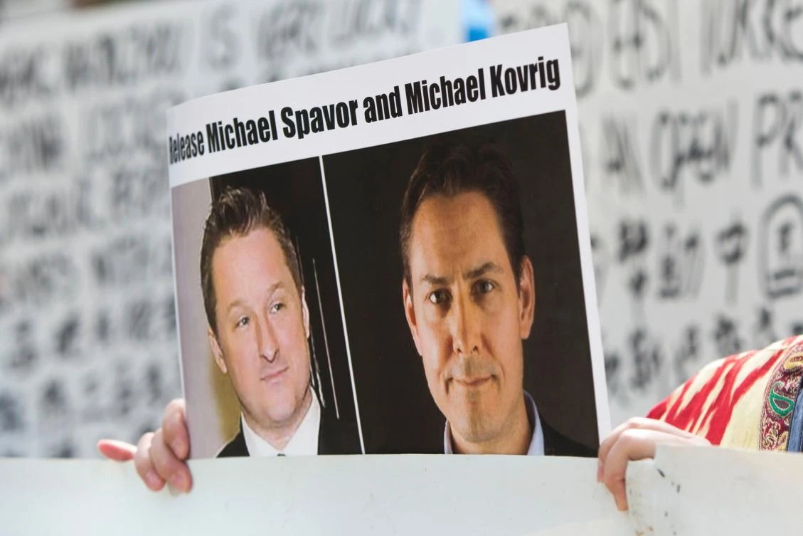 In this file photo taken on May 8, 2019, Turnisa Matsedik-Qira, of the Vancouver Uyghur Association, demonstrates against China's treatment of Uighurs while holding a photo of detained Canadians Michael Spavor (L) and Michael Kovrig outside a court appearance for Huawei Chief Financial Officer, Meng Wanzhou at the British Columbia Supreme Court in Vancouver. (File/AFP)
