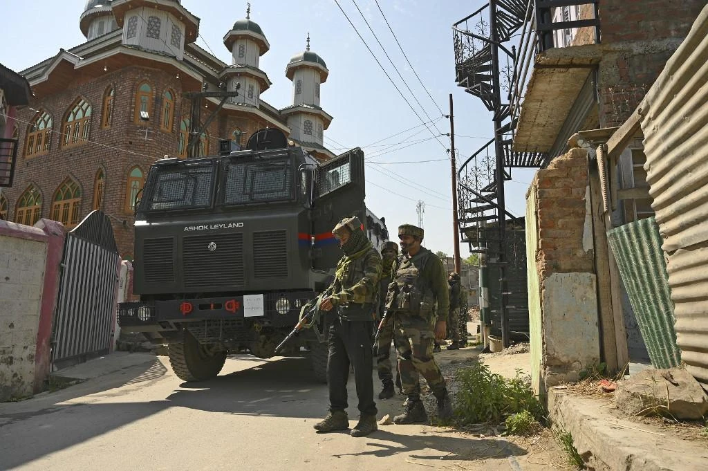 Indian army soldiers stand in front of a mosque at the site of a gunbattle at Meej Pampore area of Pulwama district, south of Srinagar on June 19, 2020. (AFP)