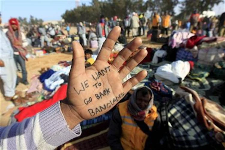 A Bangladeshi migrant worker shows a message written on his palm at the Libyan and Tunisian border crossing of Ras Jdir after fleeing unrest in Libya, March 3, 2011. (Reuters)