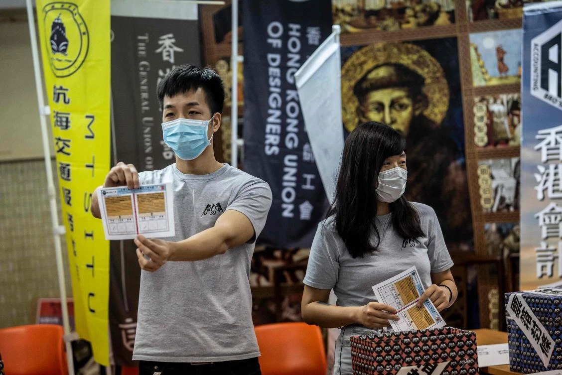 A volunteer holds up a ballot paper in Hong Kong on June 20, 2020 following a vote organized by pro-democracy unions to ask members if they will participate in a strike and if they supported China’s plans to impose a new national security law. (AFP)