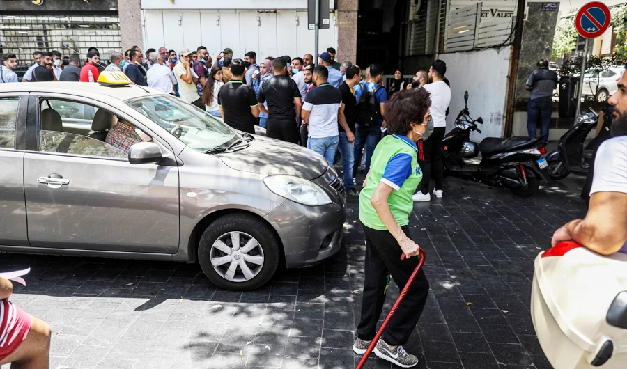 People queue outside a currency exchange bureau in Lebanon’s capital Beirut. Later, the Syndicate of Money Changers stopped selling dollars based only on identity cards. (AFP)