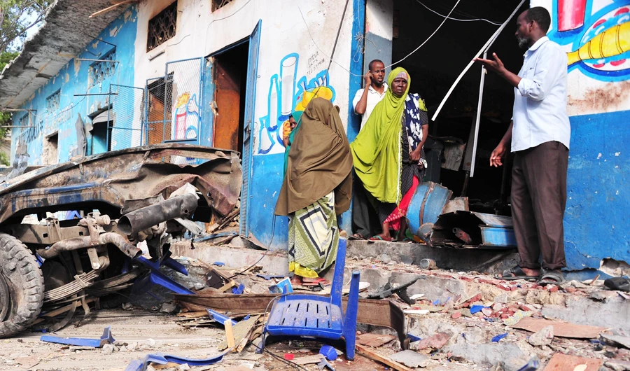 Residents walk at the scene of a blast on October 29, 2017, a day after two car bombs exploded in Mogadishu. (AFP)