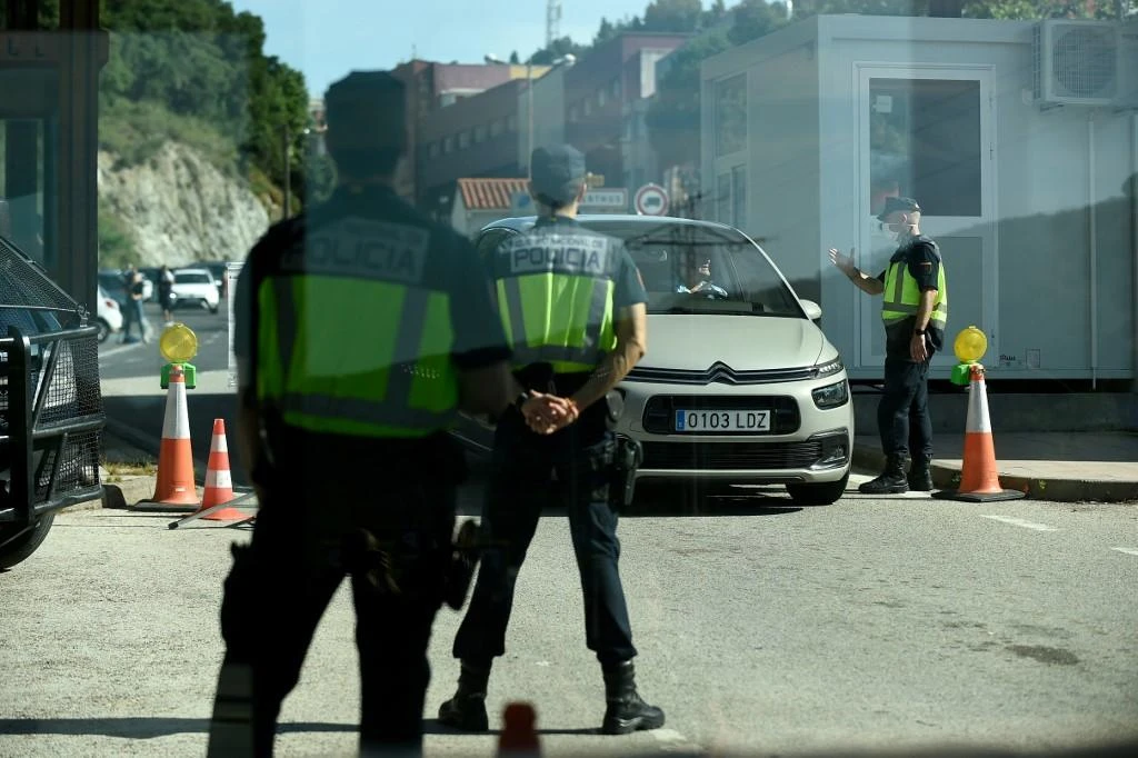 Spanish border police officers stand guard at a checkpoint as a car crosses the French-Spanish border at La Jonquera on June 21, 2020. (AFP)