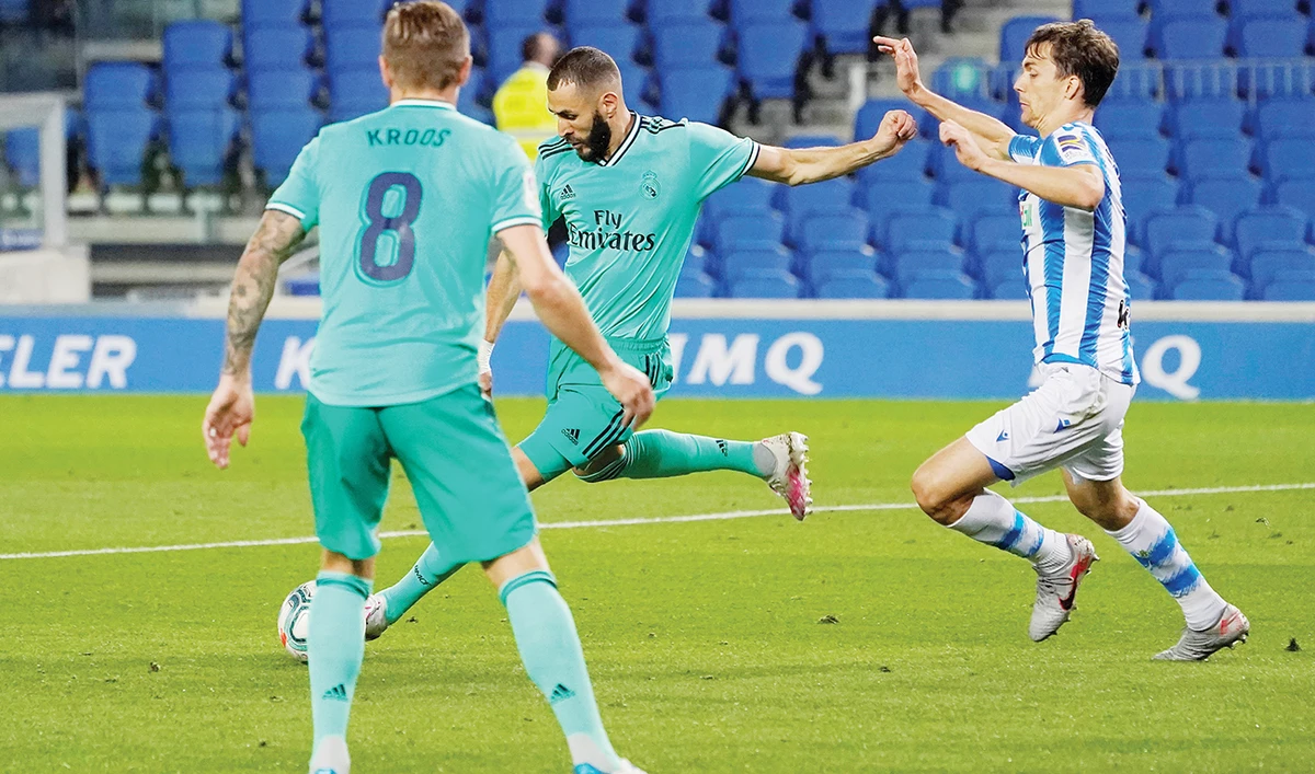 Real Madrid’s French forward Karim Benzema scores their second goal in the 2-1 victory away at Real Sociedad on Sunday, as play resumes behind closed doors. (Reuters)
