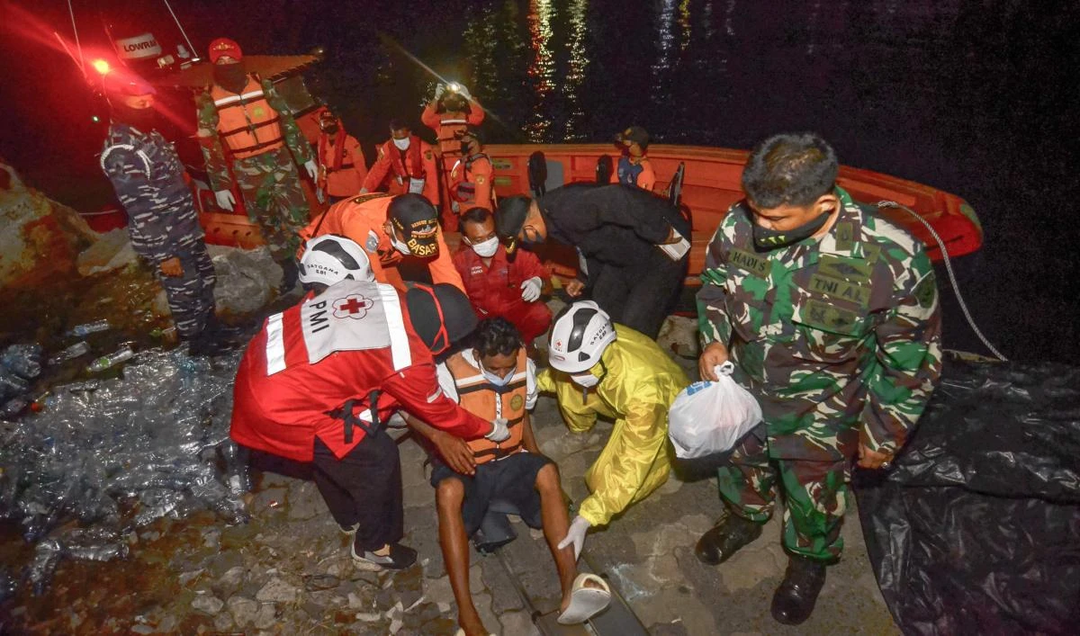 Rescue team members evacuate one of six survivors of a capsized passenger boat carrying 16 people in the Sunda strait near Anak Krakatau in Merak, Indonesia's Banten province on June 20, 2020. (AFP)