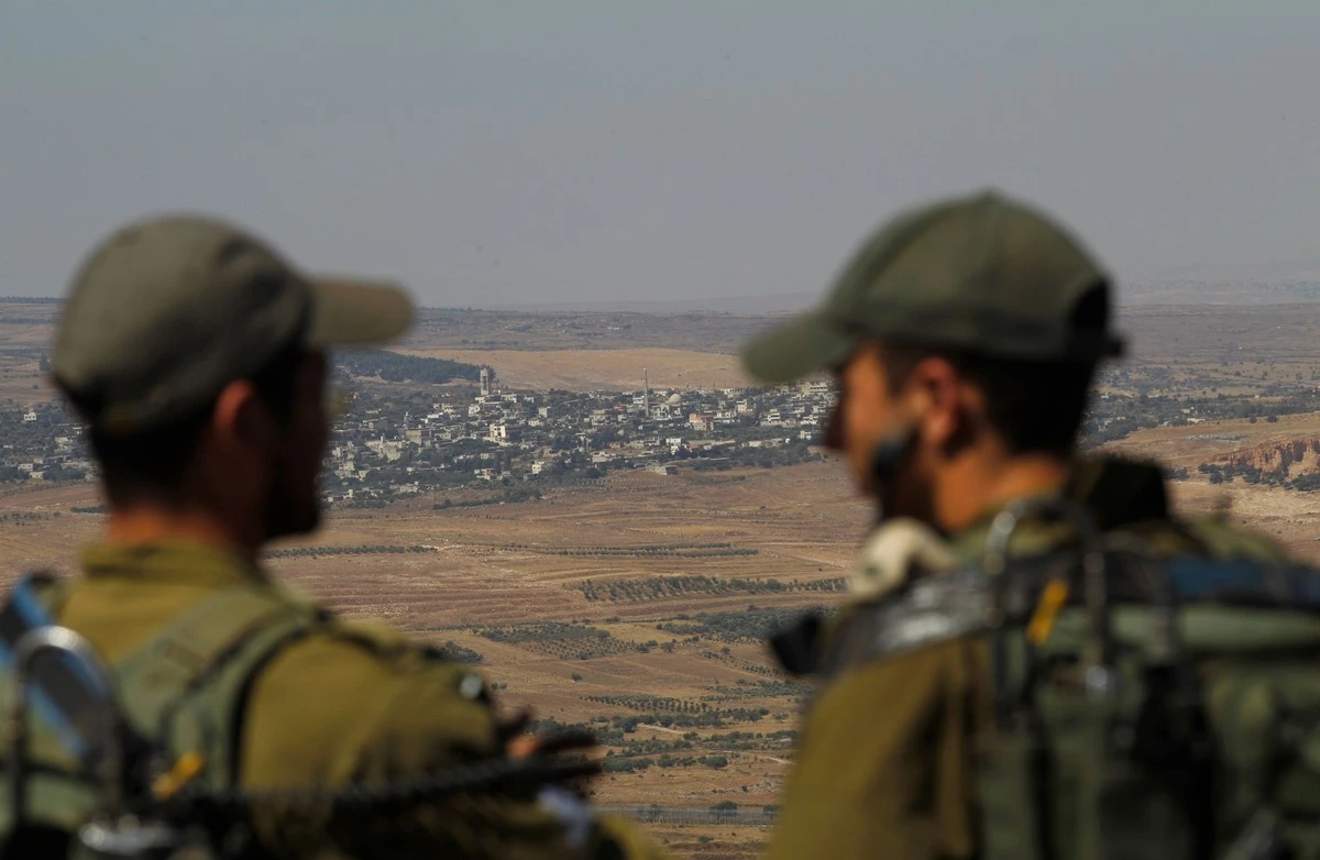 Israeli soldiers at an army base in the Golan Heights look out across the southwestern Syrian province of Quneitra. (AFP)