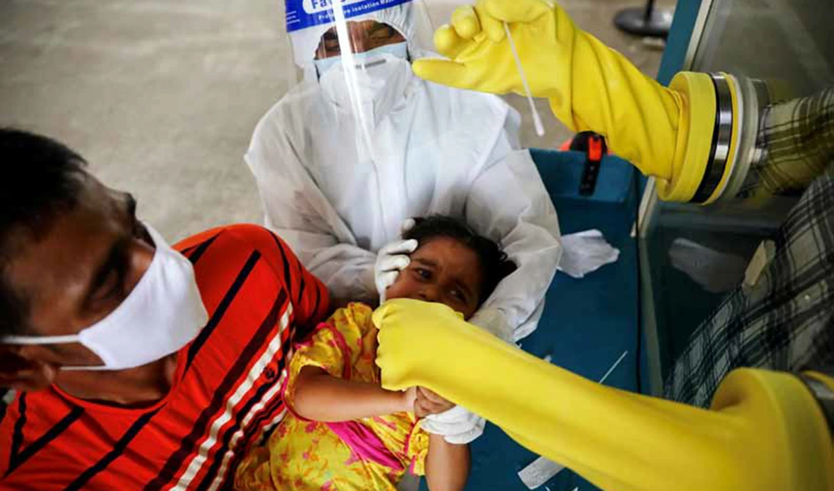 A health worker collects a swab sample from a child on Tuesday at Mugda Medical College and Hospital, as the outbreak continues in Dhaka. (Reuters)