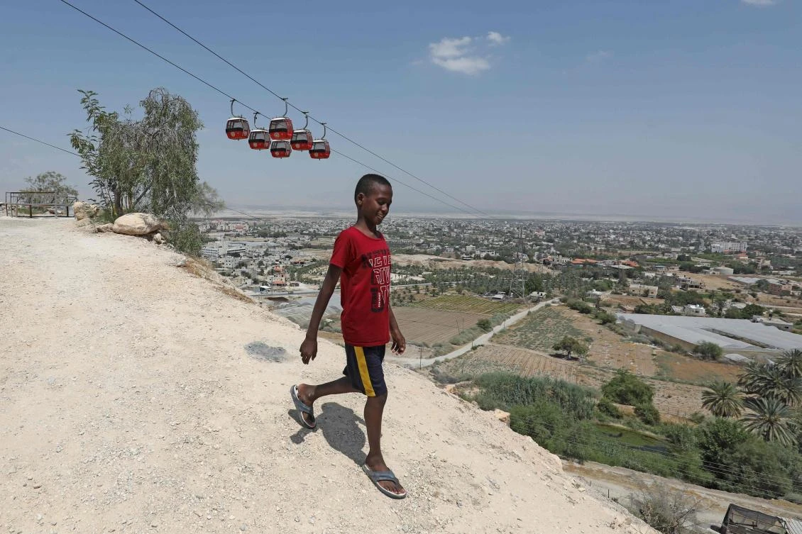 A Palestinian on a hillside overlooking Jericho, June 21, 2020. Benjamin Netanyahu, in September, pointed to a long blue zone to be annexed, leaving a brown speck in the middle: Jericho. (AFP)