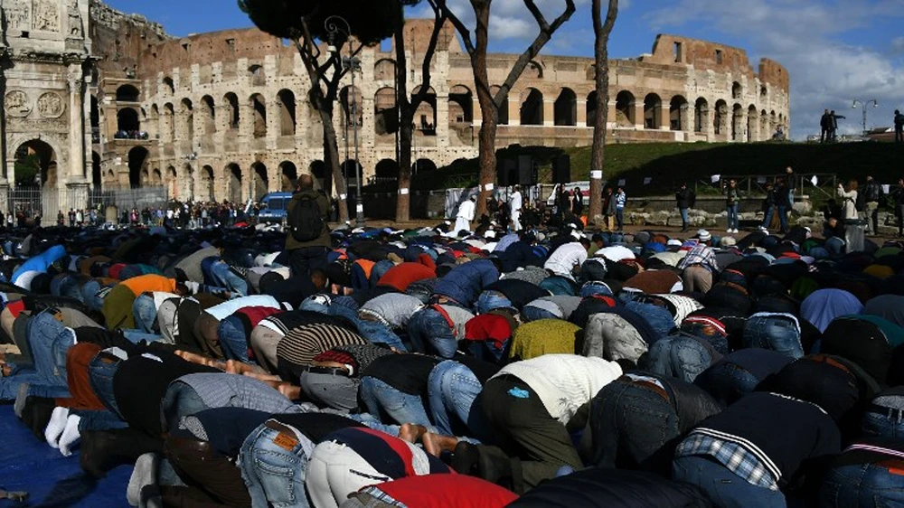 Muslims from several nationalities pray near the Colosseum in Rome. (AFP)