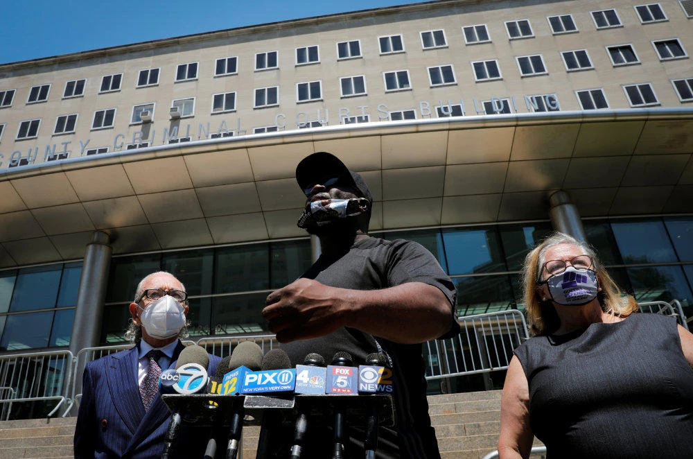 Activist Rev Kevin McCall (C) speaks to reporters outside Queens Criminal Court on June 25, 2020 with attorneys Sanford Rubenstein and Lori Zeno, following a hearing in the case of New York Police Department (NYPD) officer David Afanador, who was arrested for using an illegal chokehold to arrest a man. (REUTERS/Mike Segar)