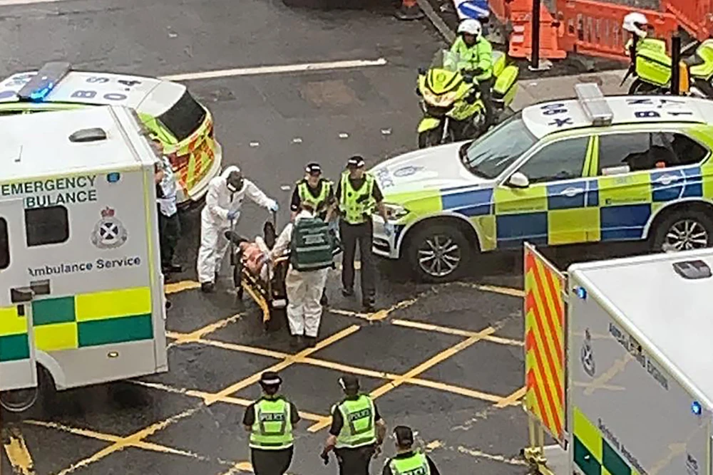 A handout picture taken from the Twitter feed of Milroy1717 shows emergency services taking a victim of an incident away on a stretcher in Glasgow city centre on June 26, 2020. (AFP/@Milroy1717)