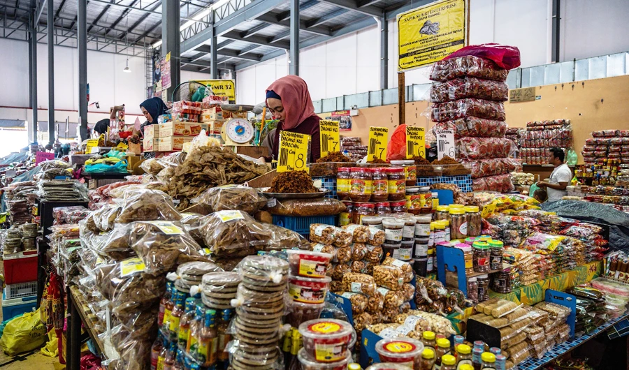 A vendor waits by her stall selling local products at the Pasar Besar Kedai Payang central market in Kuala Terengganu, in the eastern Malaysian state of Terengganu, on June 26, 2020, as sectors of the economy are being reopened following restrictions to halt the spread of the COVID-19 coronavirus. (AFP)
