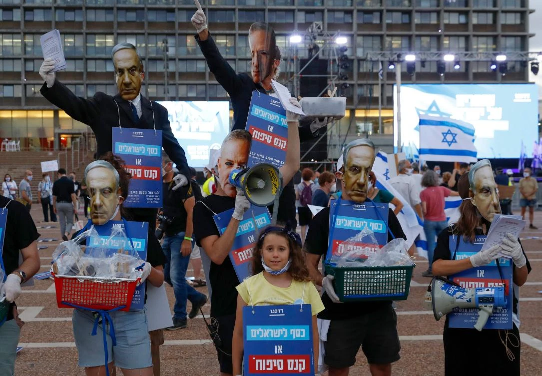 Protesters, wearing masks of Israel’s Prime Minister Benjamin Netanyahu and his coalition partner Defense Minister Benny Gantz, take part in a demonstration in Tel Aviv’s Rabin Square to denounce Israel’s plan to annex parts of the occupied West Bank, on June 23, 2020. (AFP/Jack Guez)