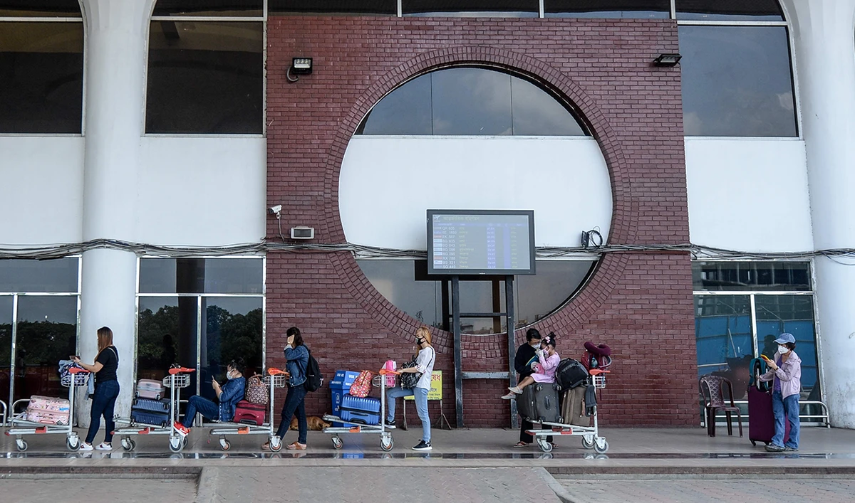 Passengers wait in a queue maintaining social distancing as a preventive measure against the spread of the COVID-19 coronavirus to enter the Hazrat Shahjalal International Airport in Dhaka on June 25, 2020. (AFP)