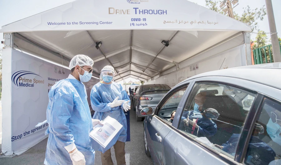 Egyptian health workers collect samples at a drive-through coronavirus- testing center at the Ain Shams University in Cairo on Monday. (AFP)