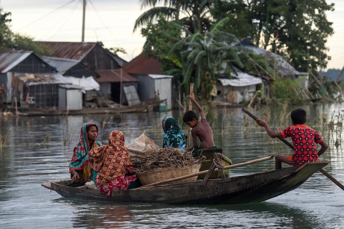 Women and children use a boat to make their way through floodwaters in Sunamganj on July 15, 2020. Almost four million people have been hit by monsoon floods in South Asia, officials said July 14, with a third of Bangladesh already underwater from some of the heaviest rains in a decade. / AFP / Munir Uz zaman