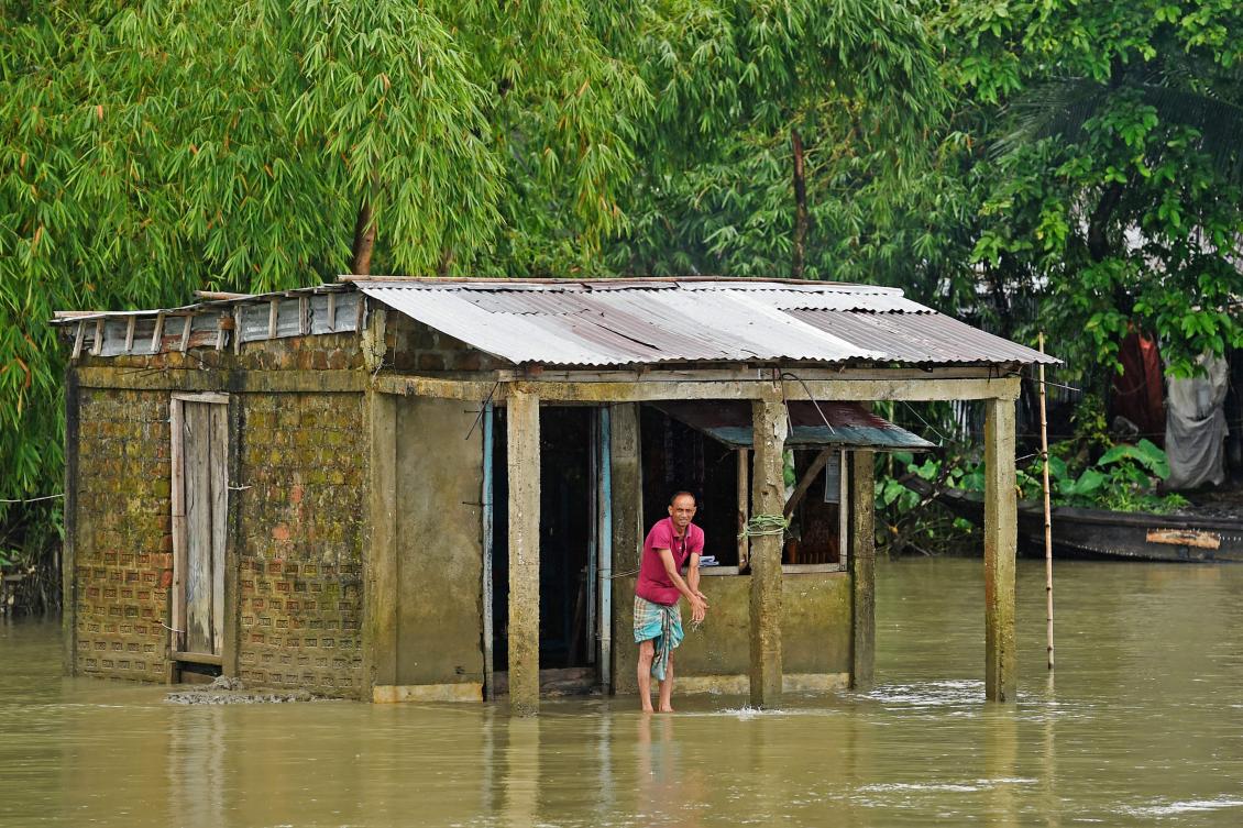 A man stands outside his flooded house in Sunamgong on July 15, 2020. Almost four million people have been hit by monsoon floods in South Asia, officials said on July 14, with a third of Bangladesh already underwater from some of the heaviest rains in a decade. / AFP / Munir Uz zaman