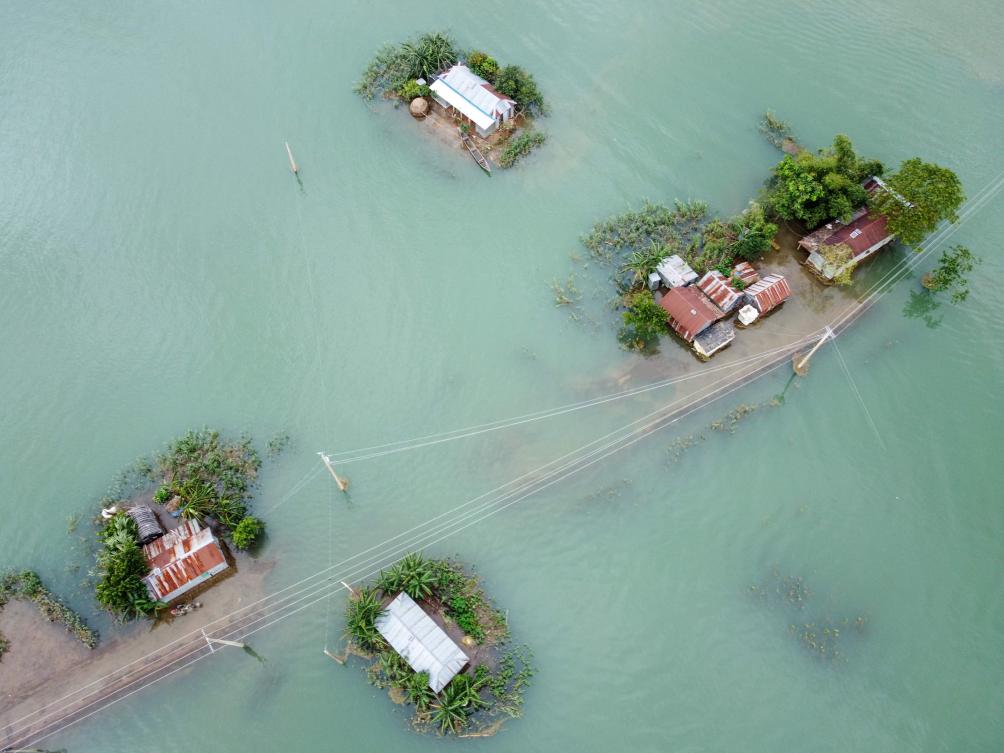 This aerial view shows flooded houses in Sunamganj on July 15, 2020. Almost four million people have been hit by monsoon floods in South Asia, officials said July 14, with a third of Bangladesh already underwater from some of the heaviest rains in a decade. / AFP / Munir Uz zaman