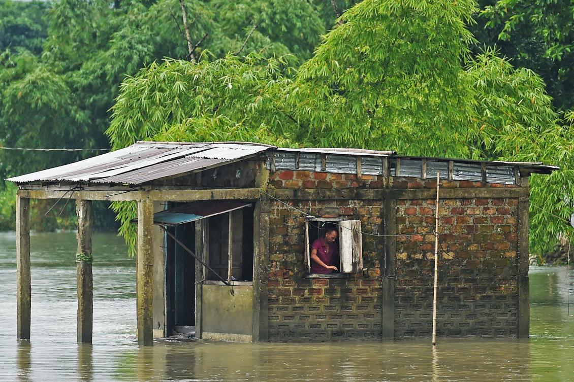 A man stands inside his flooded house in Sunamgong on July 15, 2020. Almost four million people have been hit by monsoon floods in South Asia, officials said on July 14, with a third of Bangladesh already underwater from some of the heaviest rains in a decade. / AFP / Munir Uz zaman