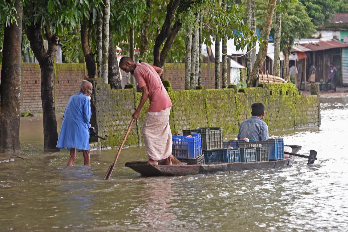 People make their way through flood waters in Sunamgong on July 15, 2020. Almost four million people have been hit by monsoon floods in South Asia, officials said on July 14, with a third of Bangladesh already underwater from some of the heaviest rains in a decade. / AFP / Munir Uz zaman