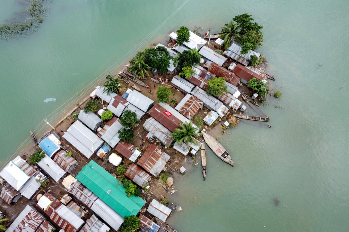This aerial view shows flooded houses in Sunamganj on July 15, 2020. Almost four million people have been hit by monsoon floods in South Asia, officials said July 14, with a third of Bangladesh already underwater from some of the heaviest rains in a decade. / AFP / Munir Uz zaman