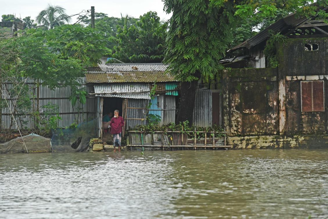 A man stands in front of his flooded house in Sunamgong on July 15, 2020. Almost four million people have been hit by monsoon floods in South Asia, officials said on July 14, with a third of Bangladesh already underwater from some of the heaviest rains in a decade. / AFP / Munir Uz zaman