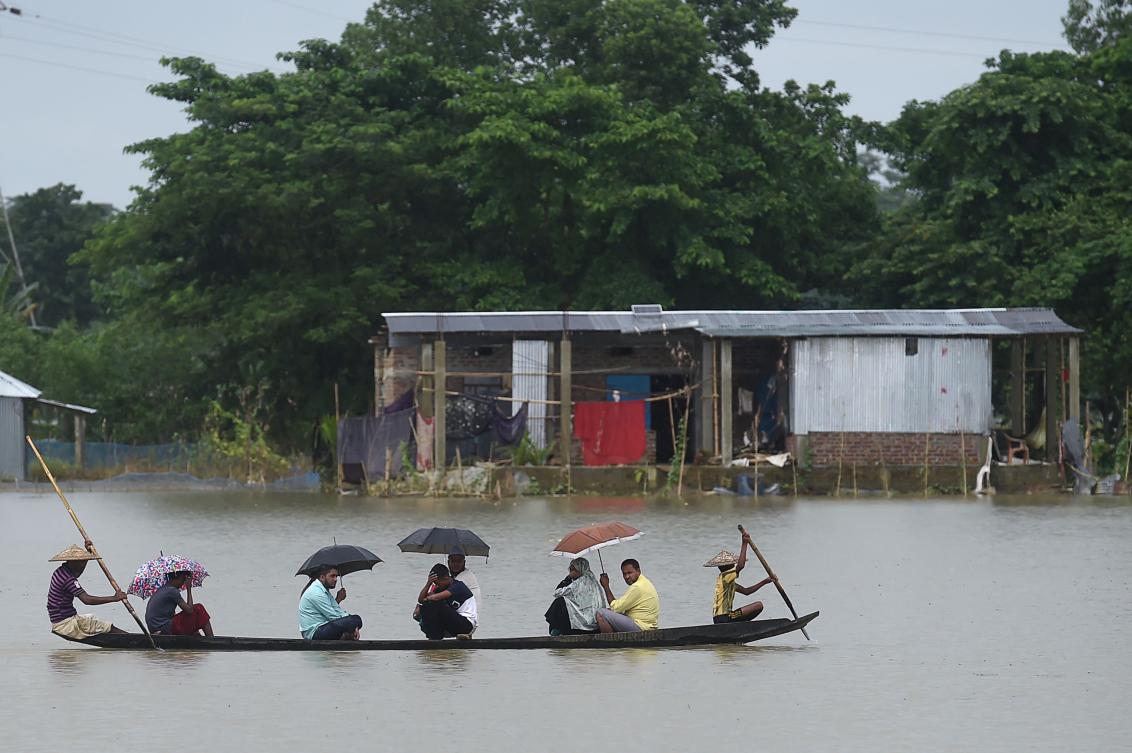 People ride on a boat through flooded waters in Sunamgong on July 14, 2020. Almost four million people have been hit by monsoon floods in South Asia, officials said July 14, with a third of Bangladesh already underwater from some of the heaviest rains in a decade. / AFP / Munir Uz zaman