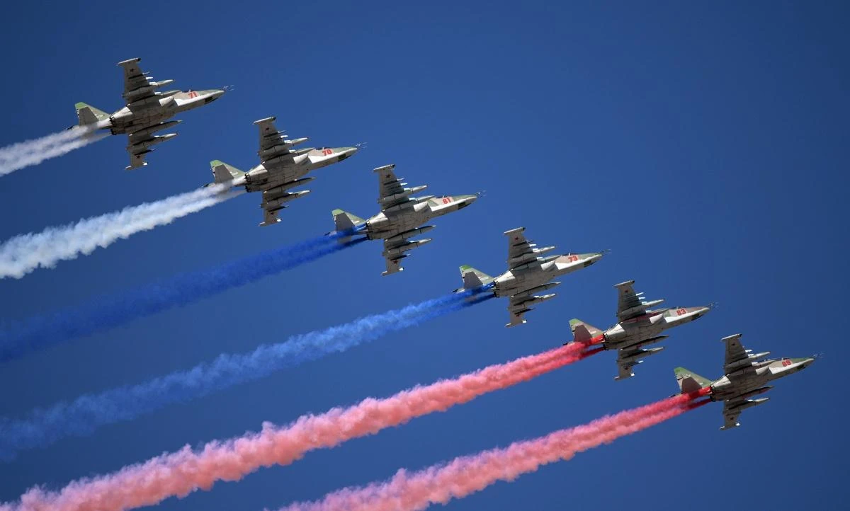 Russian Sukhoi Su-25 assault aircrafts release smoke in the colours of the Russian flag while flying over downtown Saint Petersburg during the Navy Day parade on July 26, 2020. / AFP / SPUTNIK / Alexey DRUZHININ