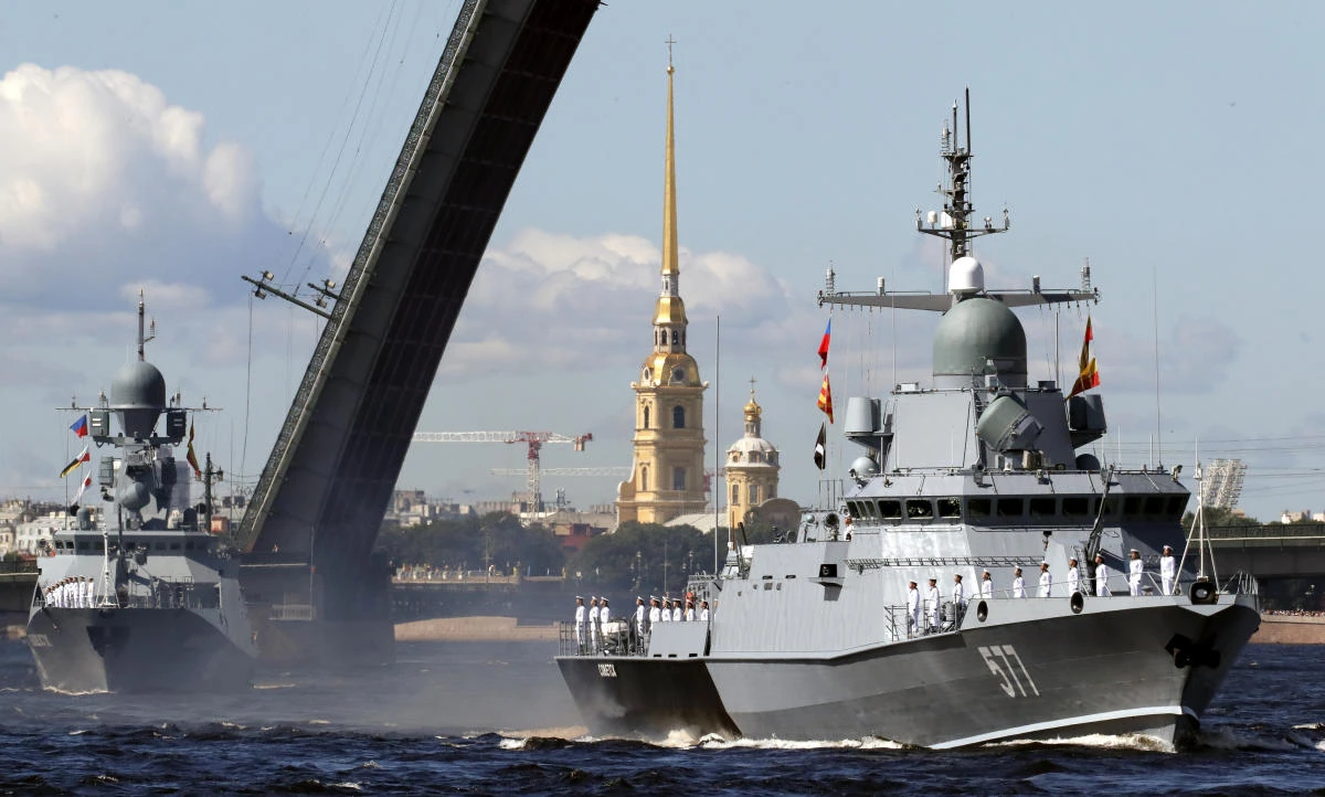 Warships float past a drawbridge rising above the Neva River during the Navy Day parade in St.Petersburg, Russia, Sunday, July 26, 2020.(AP Photo/Anatoly Maltsev, Pool)