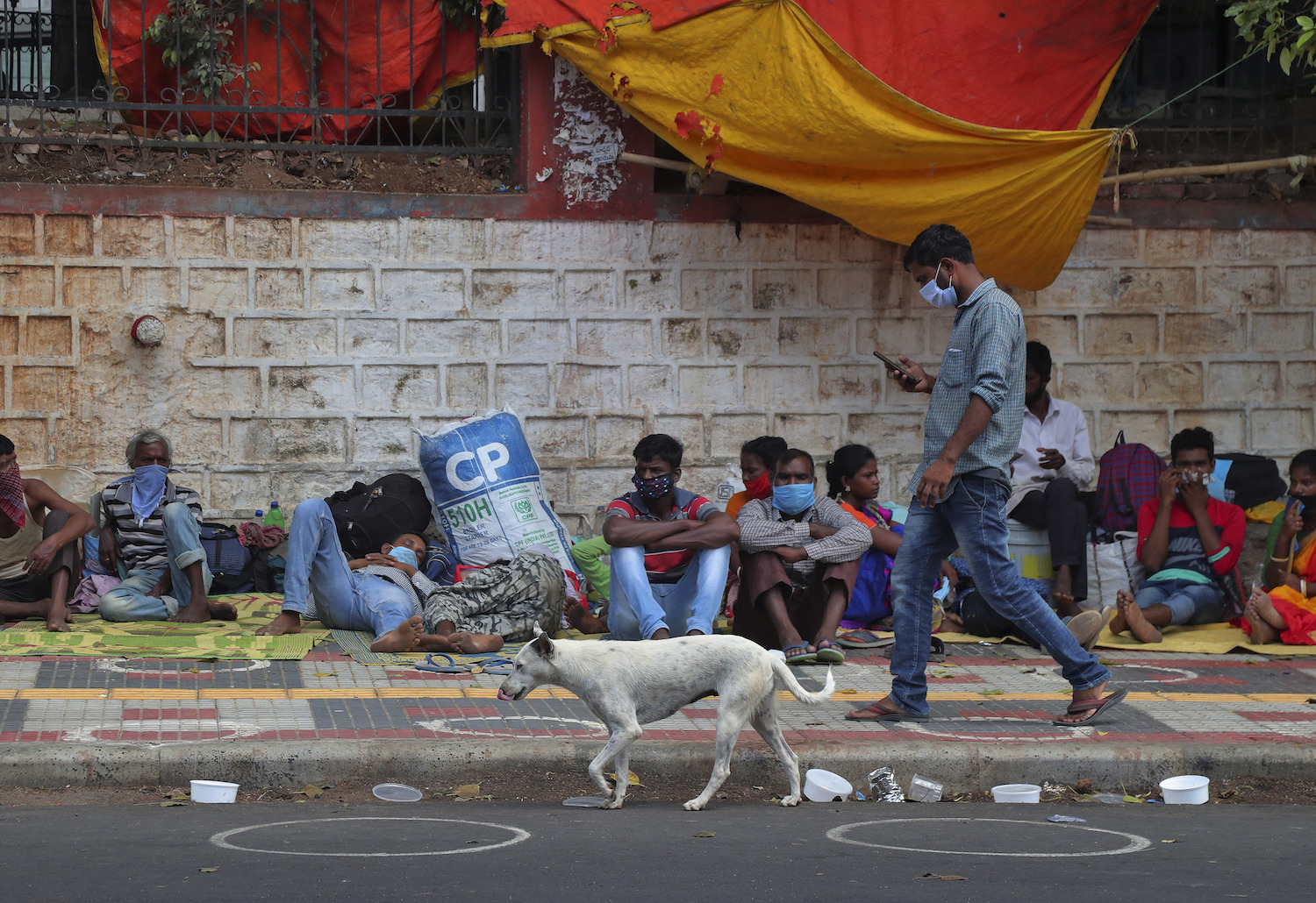 Migrant workers from other states rest on a pavement as they wait for trains to their home states in Hyderabad, India. (File/AP)