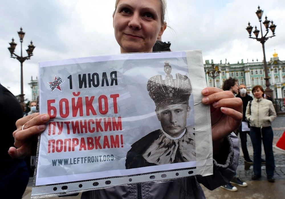 A woman holds a placard reading "Boycott to Putin's amendments" as she protests against amendments to the Constitution of Russia on Dvortsovaya Square in downtown Saint Petersburg on July 1, 2020, as Russians vote in the final day of a ballot on constitutional reforms allowing President Putin to potentially stay in power until 2036. (AFP)