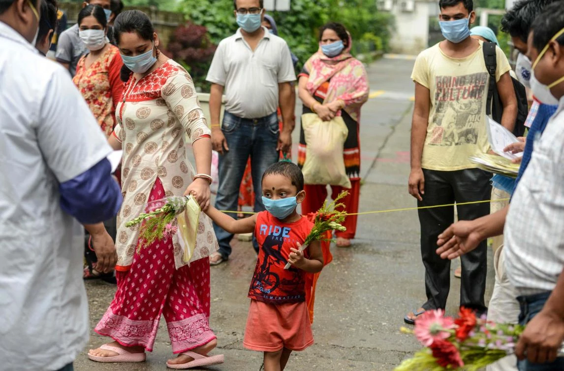 Indian medical staff hands over certificates and flowers to patients who recovered from COVID-19 after their discharge at a hospital in Siliguri on July 1, 2020. (AFP)