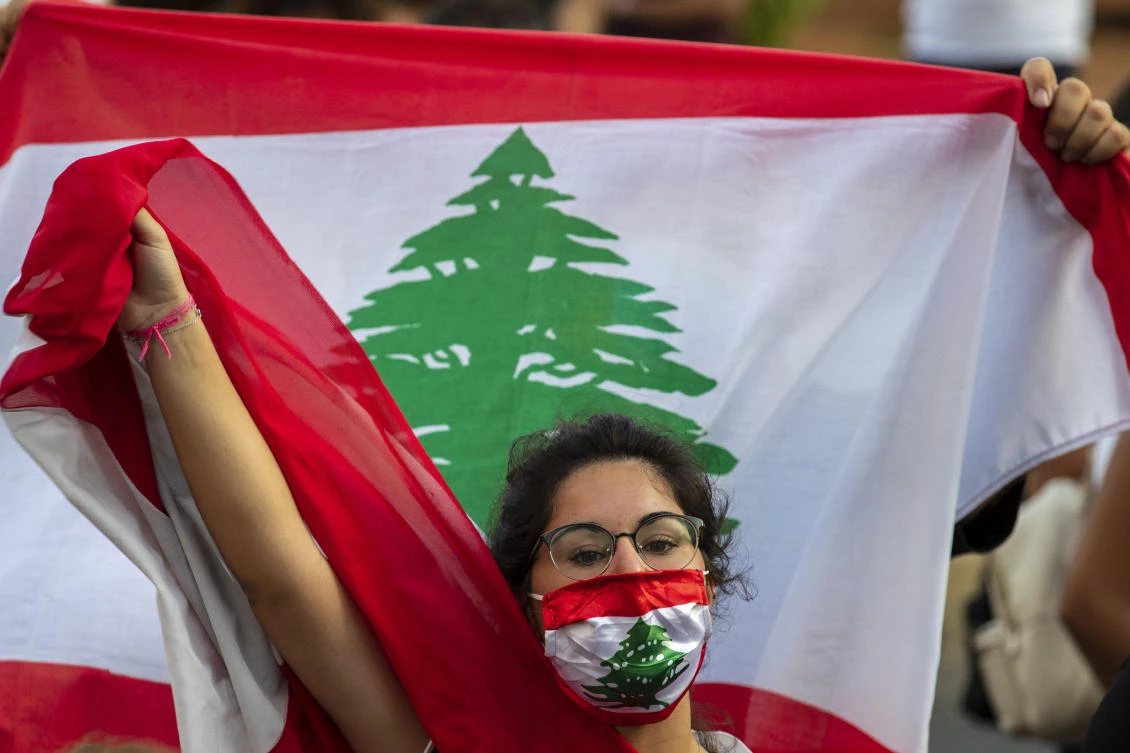 An anti-government protester shouts slogans while wearing a mask with the colors of the Lebanese flag in Beirut on Thursday, July 2, 2020. (AP)