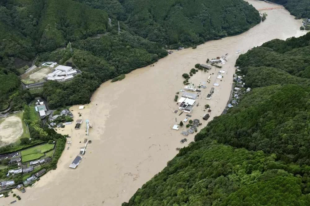 This aerial view shows the Kuma River flooded with heavy rain in Yatsushiro, Kumamoto prefecture, southwestern Japan, on Saturday. (Kyodo News via AP)