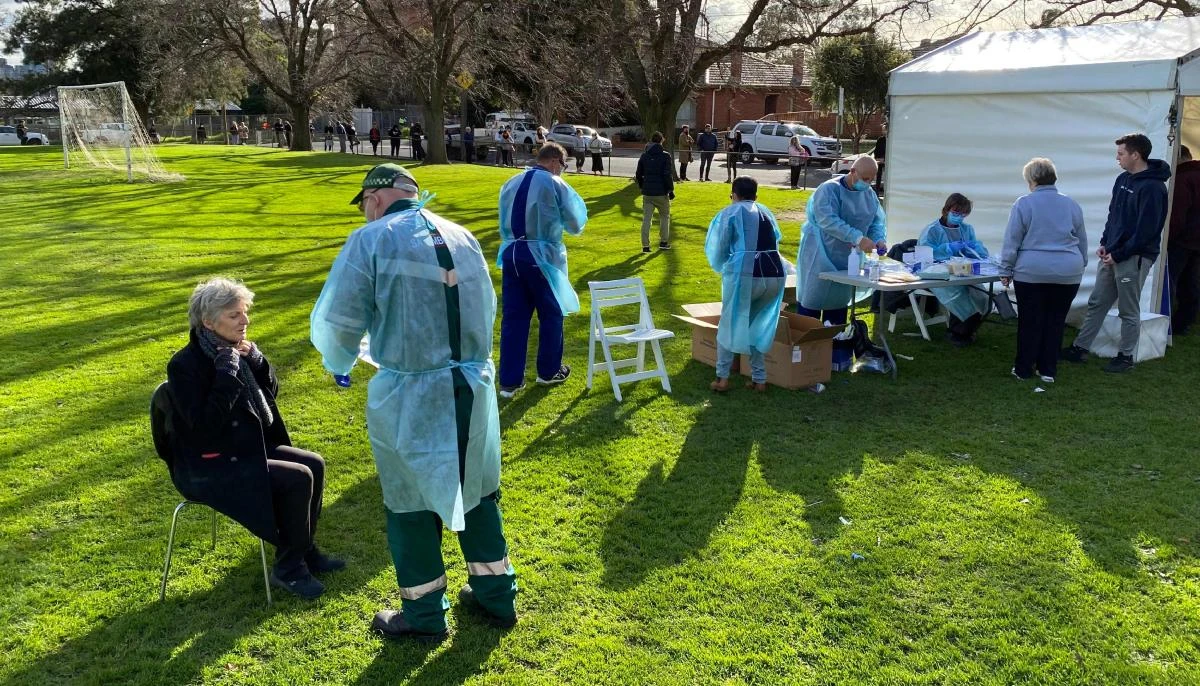 Health workers take swab samples as people queue during COVID-19 coronavirus testing in a park in the Melbourne suburb of Brunswick West on July 2, 2020. (AFP)