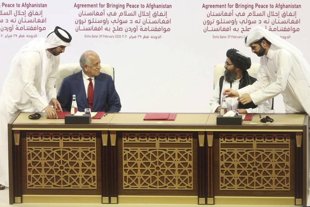 In this Feb. 29, 2020 file photo, U.S. peace envoy Zalmay Khalilzad, left, and Mullah Abdul Ghani Baradar, the Taliban group's top political leader sign a peace agreement between Taliban and U.S. officials in Doha, Qatar. (AP Photo)