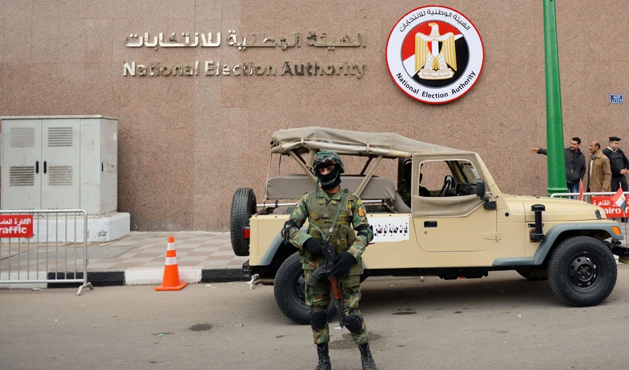A member of the Egyptian special forces stands guard in front of the National Election Authority, in Cairo on January 24, 2018. (AFP)